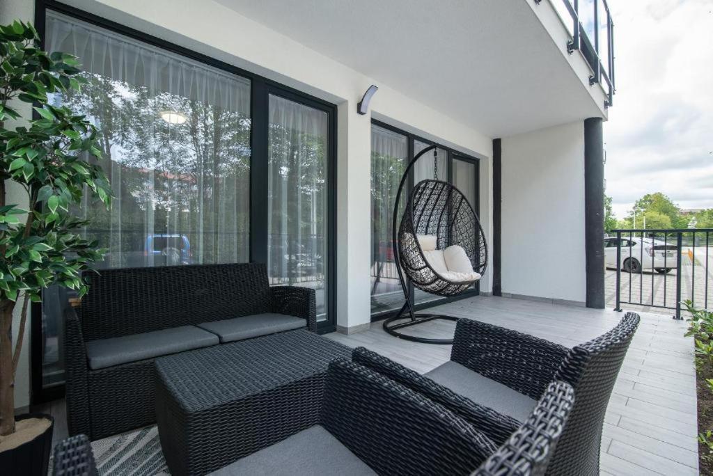 a screened in porch with a couch and chairs at JASTRZĘBIA GÓRA Rozewska 44 apartament A01 in Tupadły