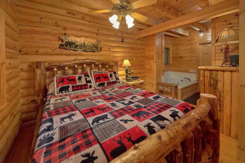 a bedroom with a bed in a log cabin at Camp Cozy in Pigeon Forge