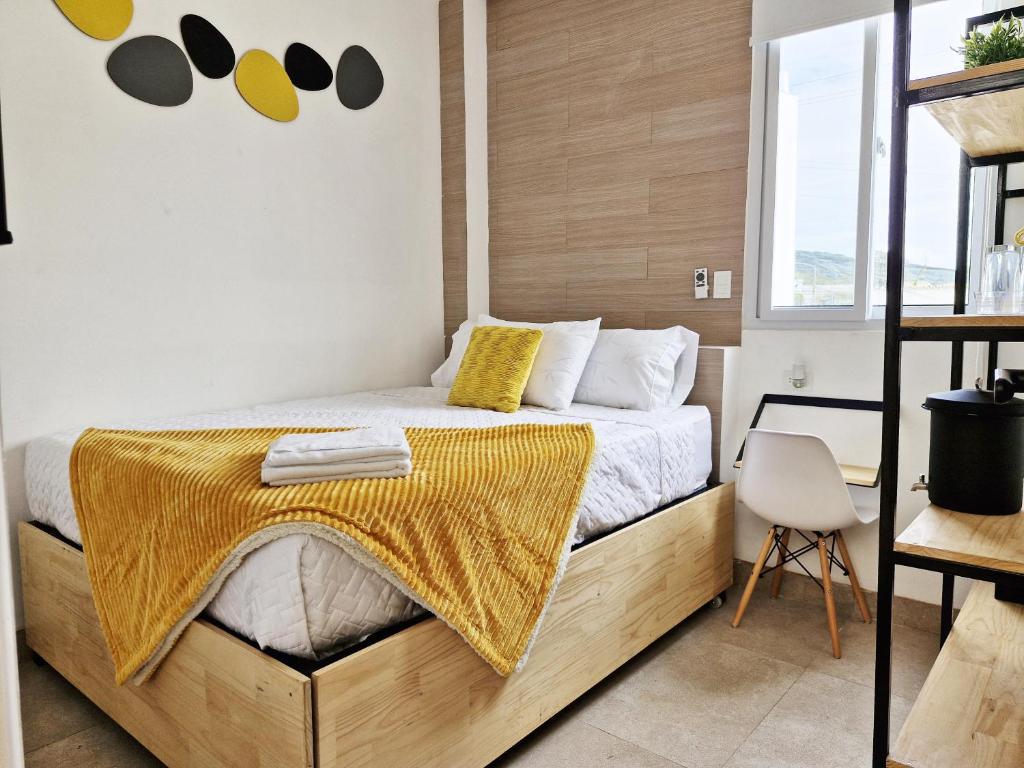 a bedroom with a bed with a yellow blanket on it at Comoda, Confortable Cerca Miraflores Fórum Majadas H10 in El Rodeo