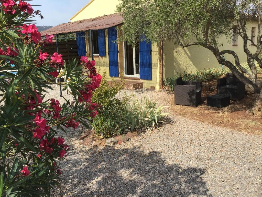 une maison avec des fleurs roses devant elle dans l'établissement Gîte des oliviers, au Luc