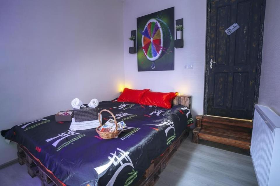 Schlafzimmer mit einem Bett und einer Holzbank in der Unterkunft Sokolov apartments in Tbilisi City