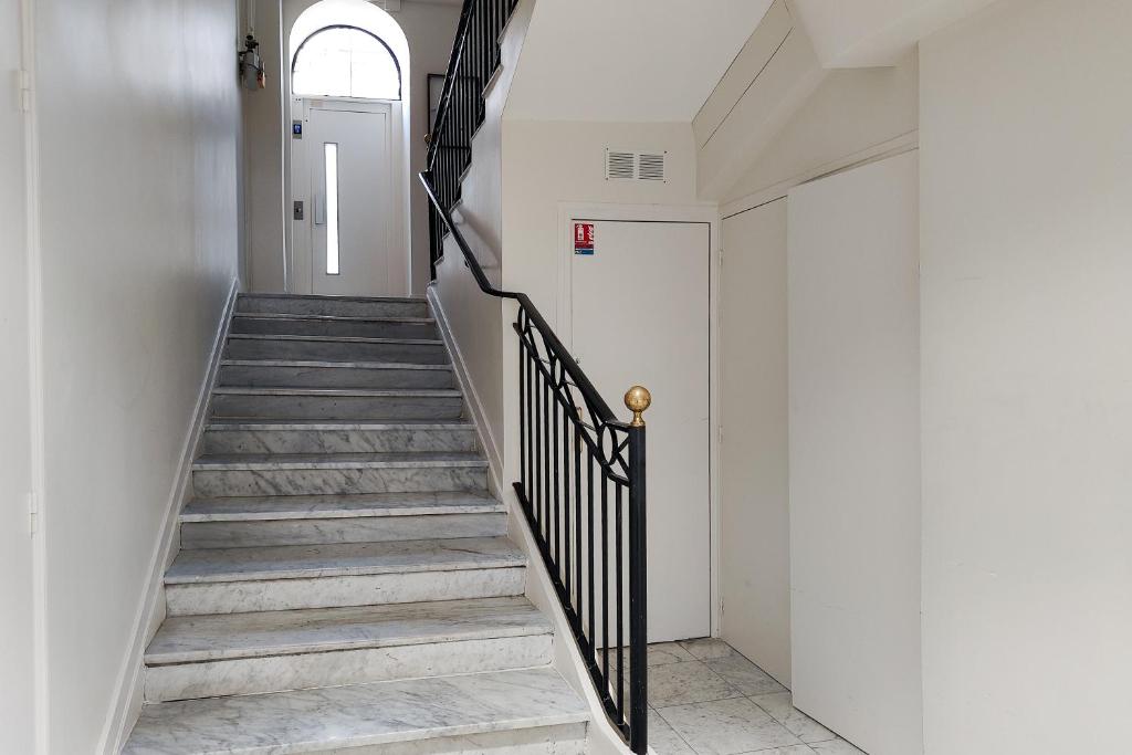 un couloir avec des escaliers et une porte blanche. dans l'établissement Aparthotel AMMI Nice Massena - ex Ajoupa, à Nice