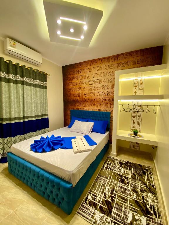 a bedroom with a bed with a blue head board at Horus pyramids view in Cairo
