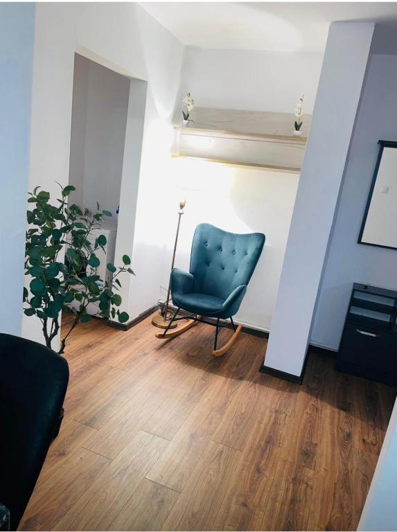 a living room with a chair and a plant at Apartament Tudorache Premium in Turceni
