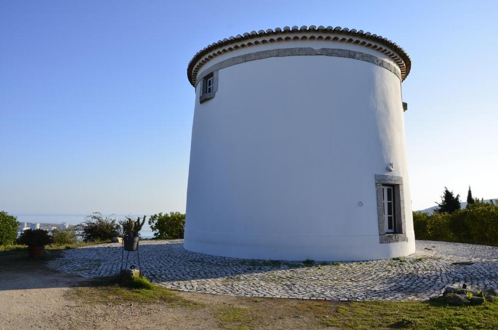 a white building with a large door on a hill at Ha Mar ao Luar in Setúbal