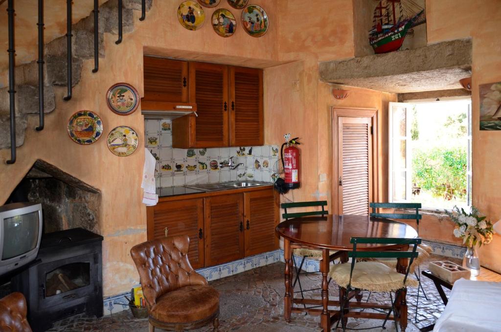 a kitchen with a table and chairs and a stove at Ha Mar ao Luar in Setúbal