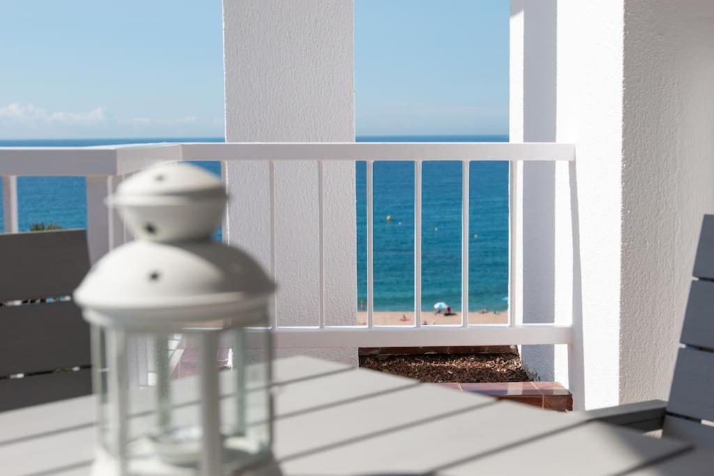 una vista del océano desde un balcón en SeaHomes Vacations - Seafront Apt Fenals with PKG, en Lloret de Mar