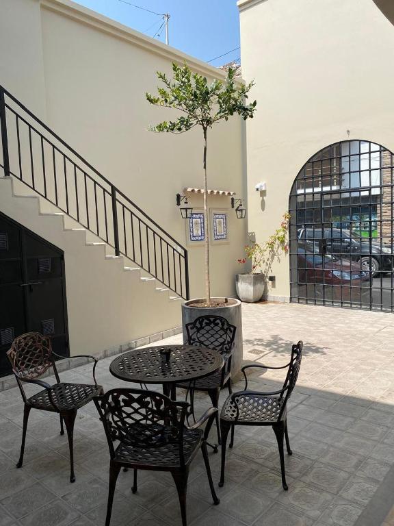 a patio with a table and chairs and a tree at Posada del Milagro in Salta