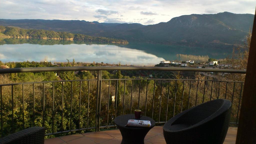a balcony with two chairs and a view of a lake at Casa El Mirador de Nicolas in La Puebla de Castro