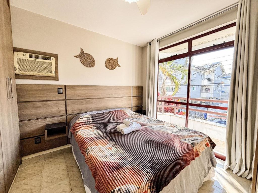 une chambre avec un lit et une grande fenêtre dans l'établissement Apê Família, A/C e 3 Quartos | 450m Canasvieiras, à Florianópolis
