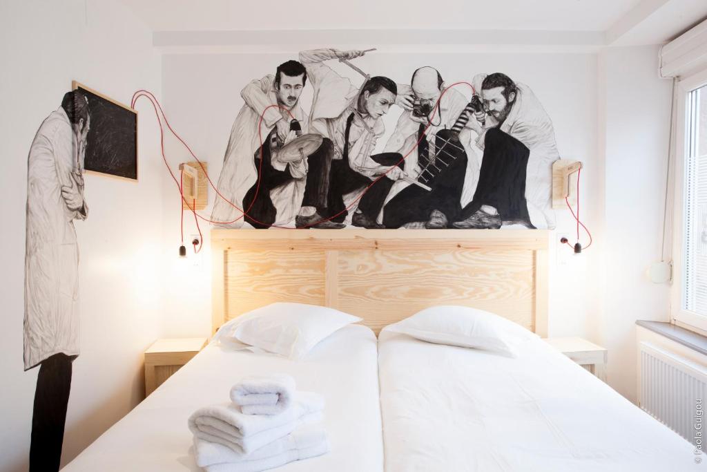a bedroom with a bed with a drawing on the wall at Hôtel Graffalgar in Strasbourg