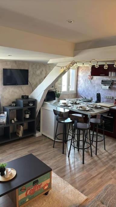 une cuisine avec un comptoir et une table avec des tabourets dans l'établissement Le Petit Ardennais, à Charleville-Mézières