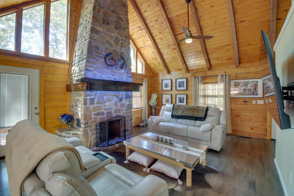 a large living room with a stone fireplace at Hot Springs Cabin w/ Deck + Mountain Views! in Hot Springs