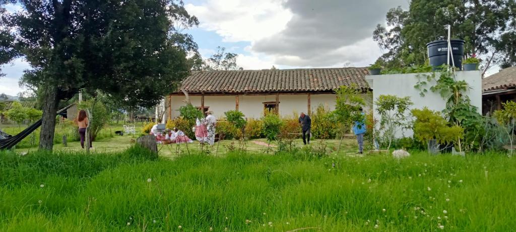 a group of people standing in a yard next to a house at Posada Turistica Altamisal in Firavitoba