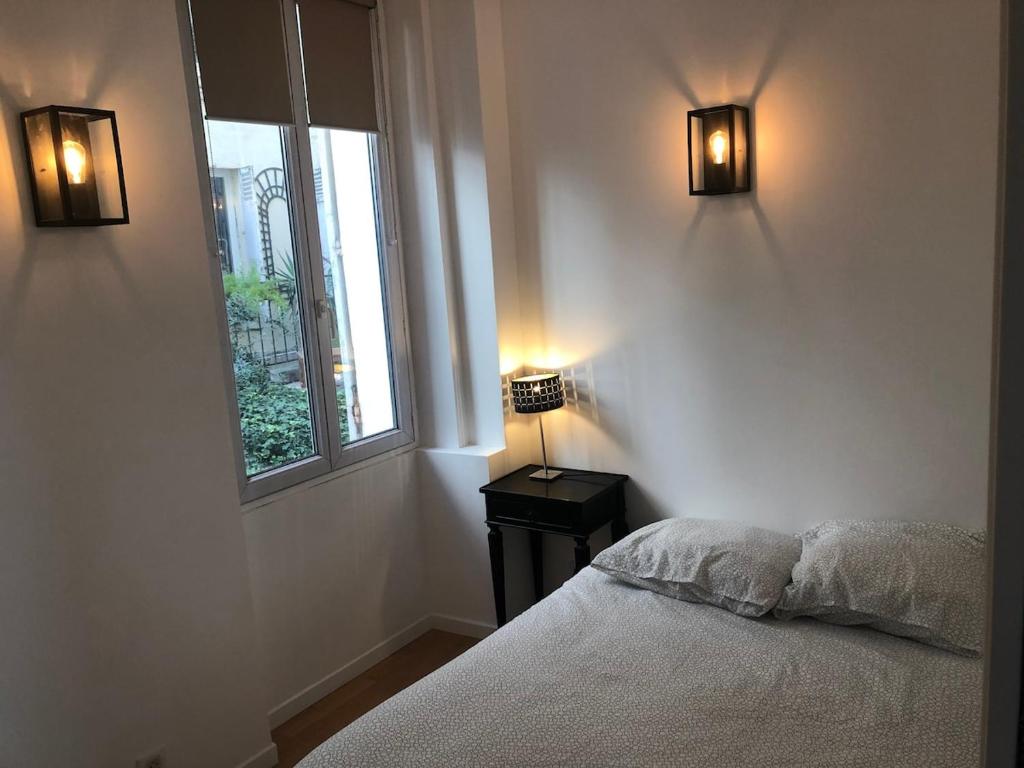 - une chambre avec un lit et deux lumières sur le mur dans l'établissement Loft 2 BR Loft Effeil tower AC by LCC Agency, à Paris