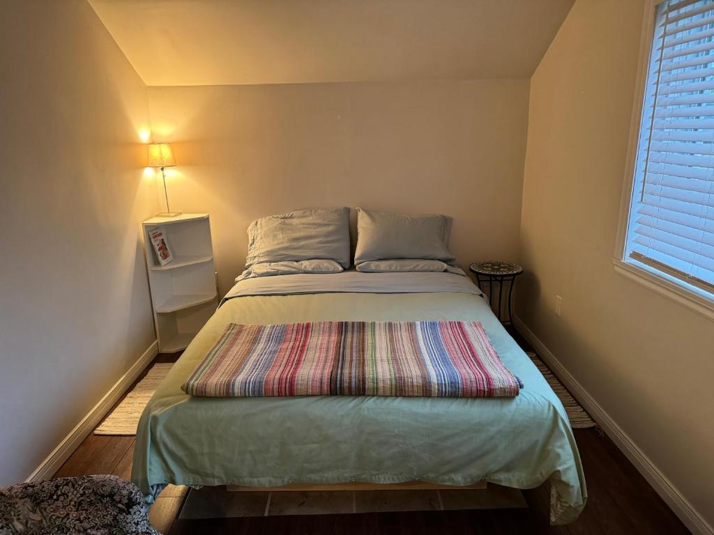 a small bedroom with a bed with a colorful blanket at Loft Nature Laurentides in Val-des-Lacs