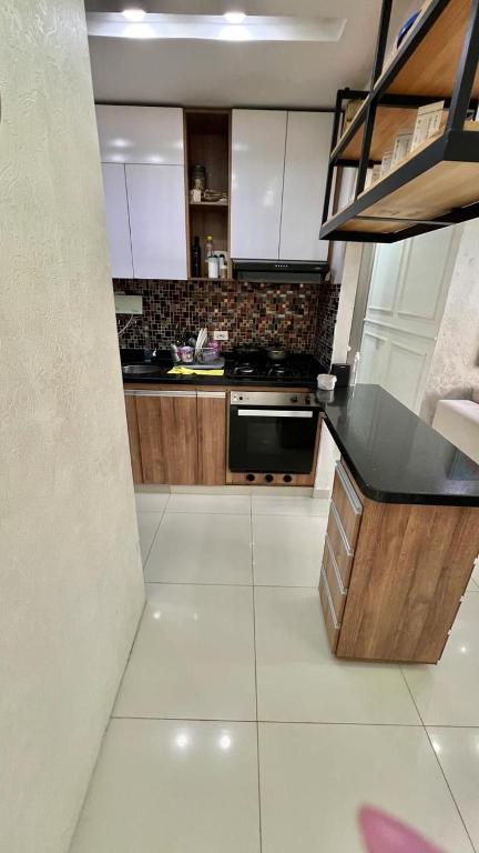 eine Küche mit weißen Schränken und einer schwarzen Arbeitsplatte in der Unterkunft Upar Suite Apartamento con Aire Acondicionado y piscina in Valledupar