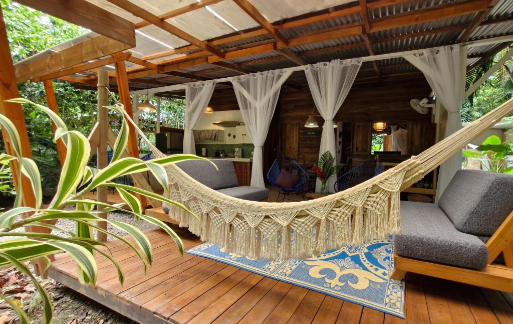 eine Hängematte auf der Terrasse eines Hauses in der Unterkunft Up! House ~ Charming and cozy ~ 4 guests in Playa Chiquita in Cocles