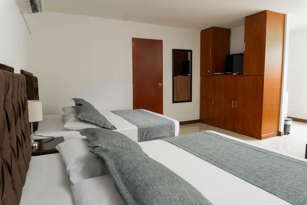 Postel nebo postele na pokoji v ubytování Hotel Palo Alto Laureles