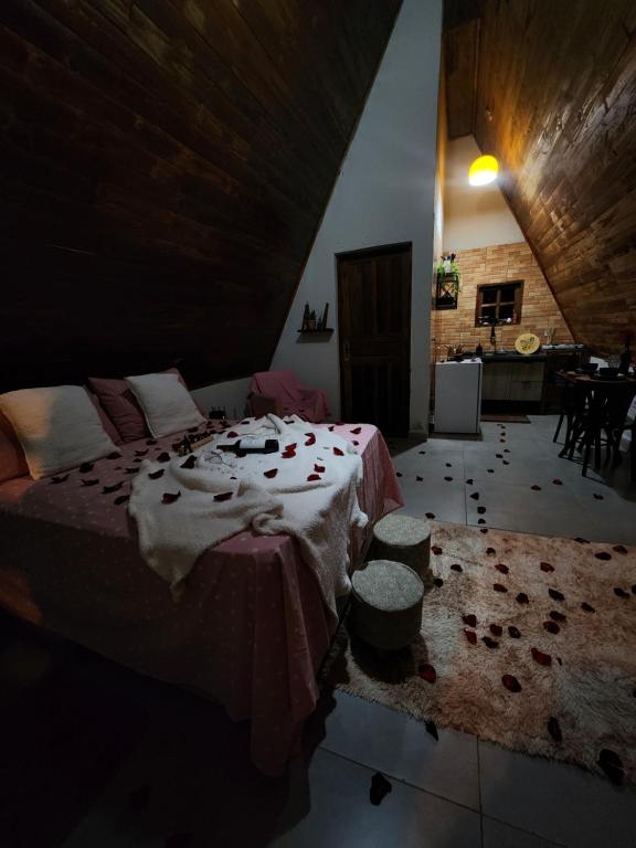 a bedroom with a large bed and a kitchen at Elshadaychale in Ibiúna