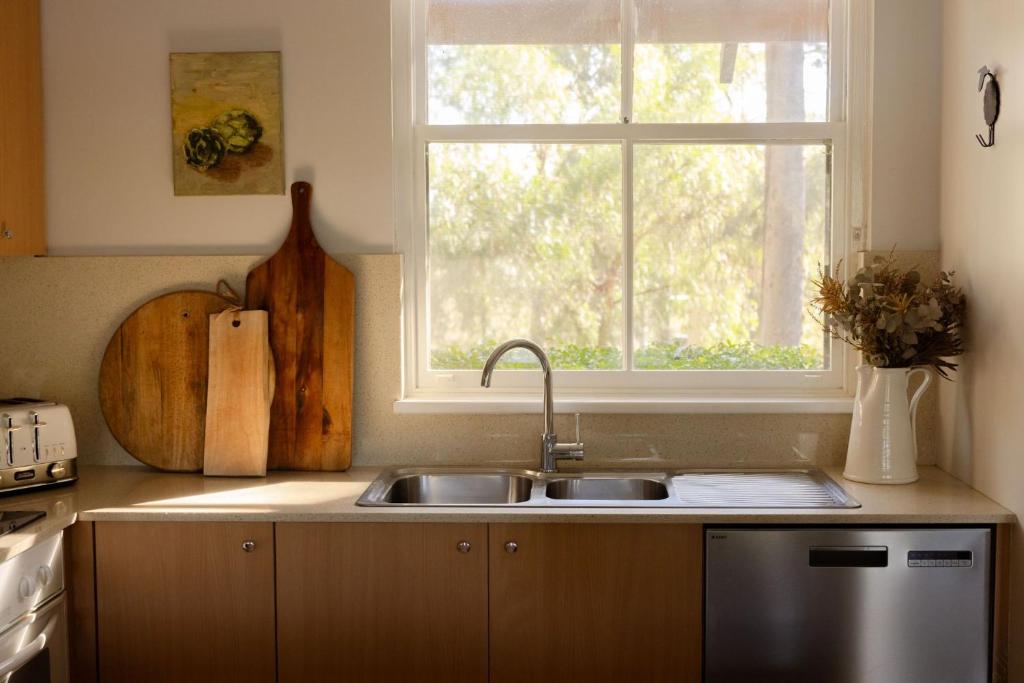 a kitchen with a sink and a window at Villa 3br Tempranillo Villa located within Cypress Lakes Resort in Pokolbin