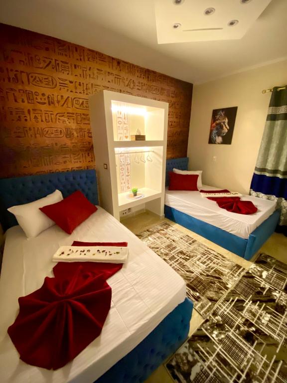 a bedroom with two beds with red pillows at Horus pyramids view in Cairo