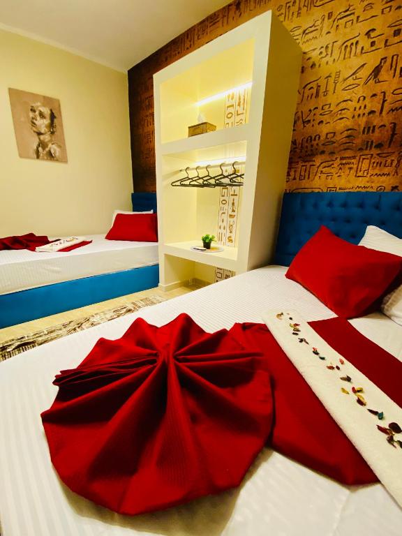 a bedroom with two beds with a red bow on the bed at Horus pyramids view in Cairo