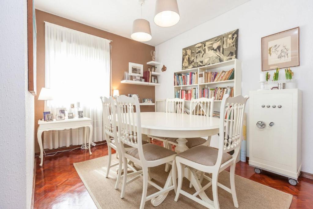 biała jadalnia z białym stołem i krzesłami w obiekcie Casa De Salgueiros w Porto