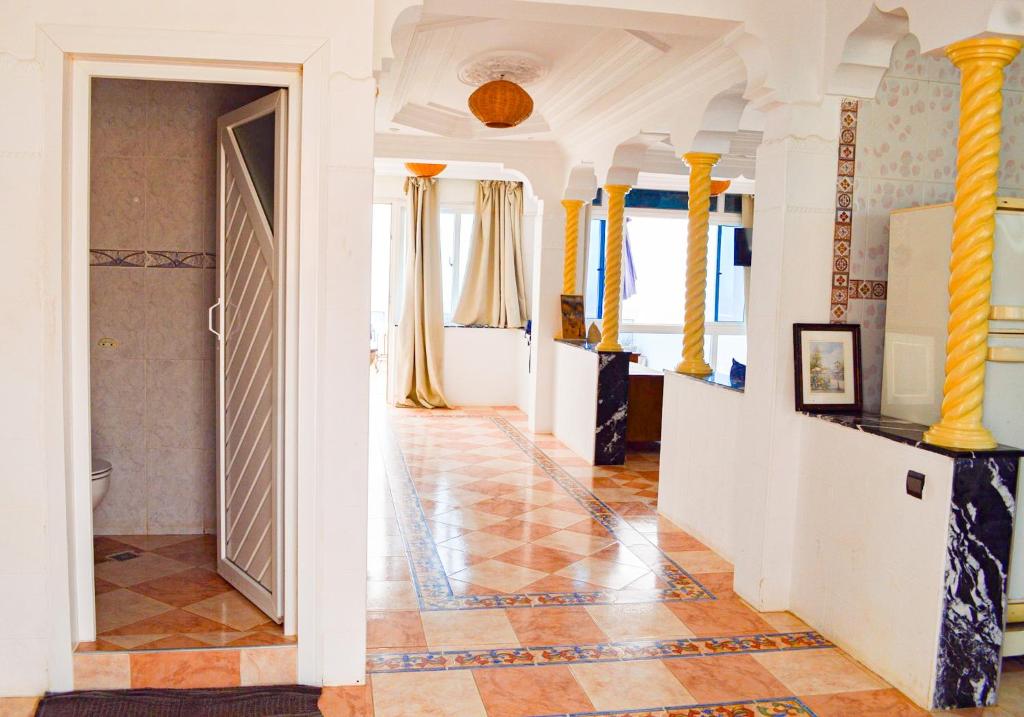 A person working on a laptop in a comfortable common area with surfboards in the background.