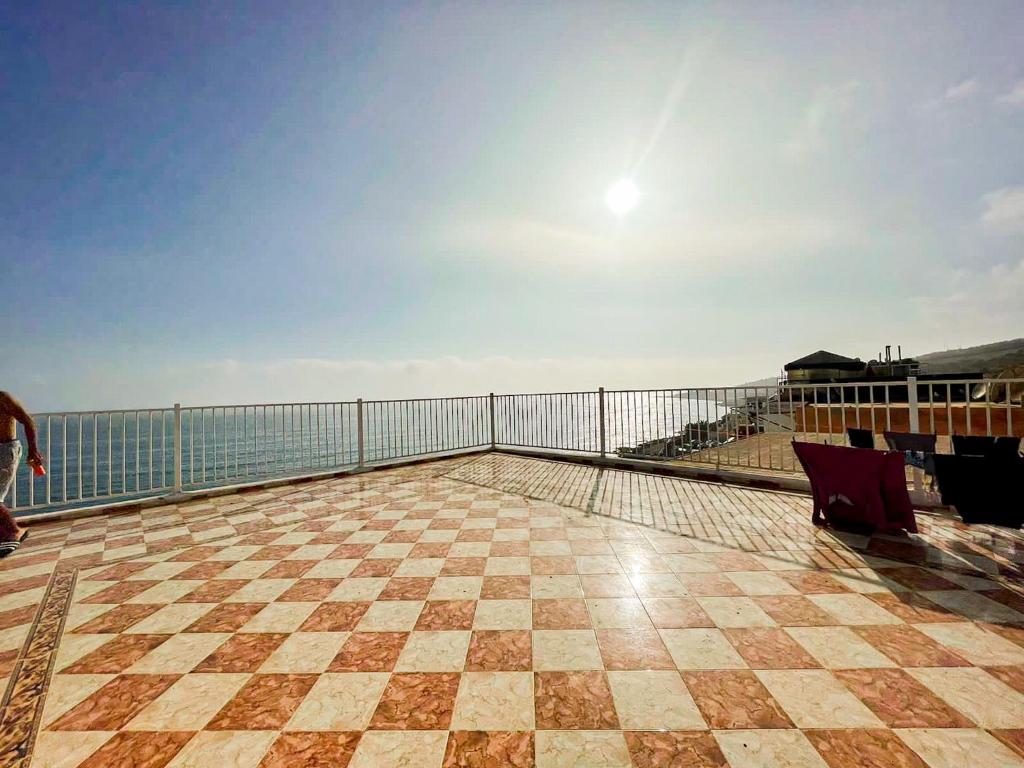Woman doing yoga on a rooftop at sunrise with an ocean view