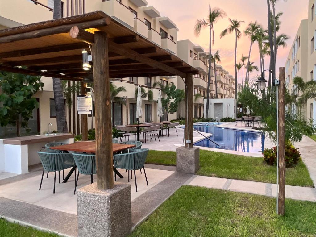 eine Terrasse mit Tisch und Stühlen neben einem Pool in der Unterkunft LOFT NUEVO ! En Cerritos OCEANNA frente al MAR ! - 237 B - in Mazatlán