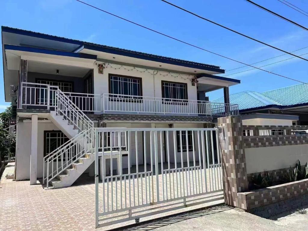 a house with a white fence and a gate at Amberhouse 1 in Semporna