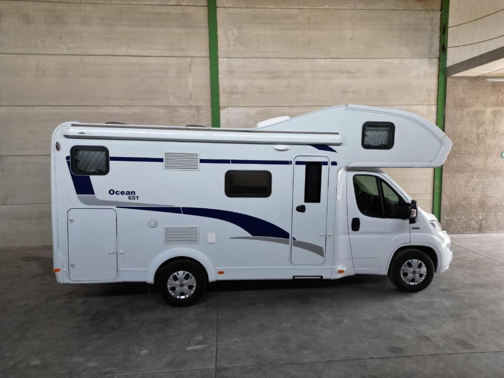 un camper bianco parcheggiato in un parcheggio di Autocaravanmadrid a El Espinar