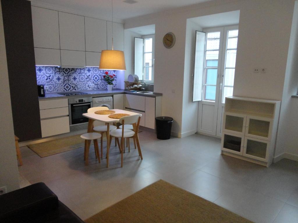 a kitchen with a table and chairs in a room at Casa Aveiro Canal da Ria in Aveiro