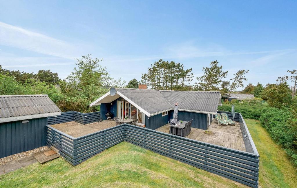 a house with a large backyard with a deck at Holiday Home Hvide Sande With A Patio 04 in Bjerregård