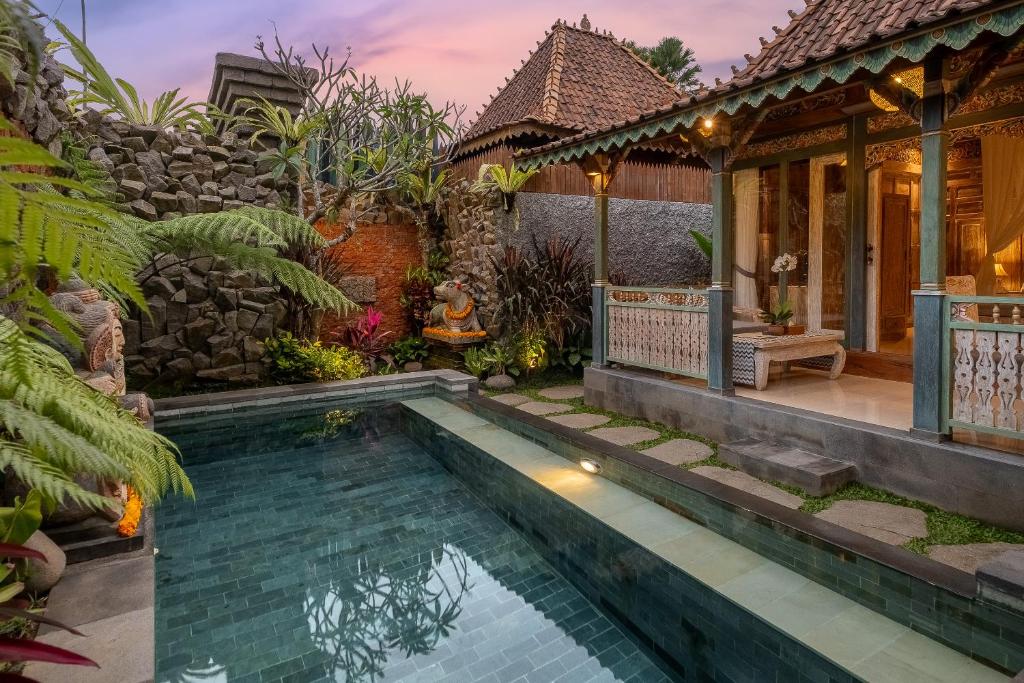 a house with a swimming pool in front of a house at Astala Ubud Villa in Ubud
