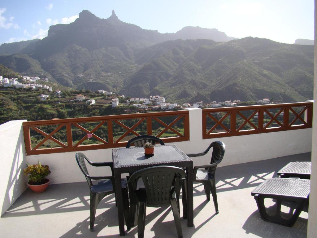 a table and chairs on a balcony with mountains at Casa Rural Paisajes de Tejeda in Tejeda