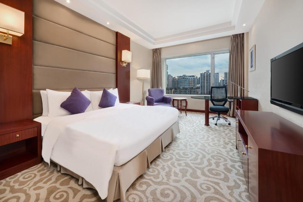 a hotel room with a large bed and a desk at Crowne Plaza Shanghai by IHG in Shanghai