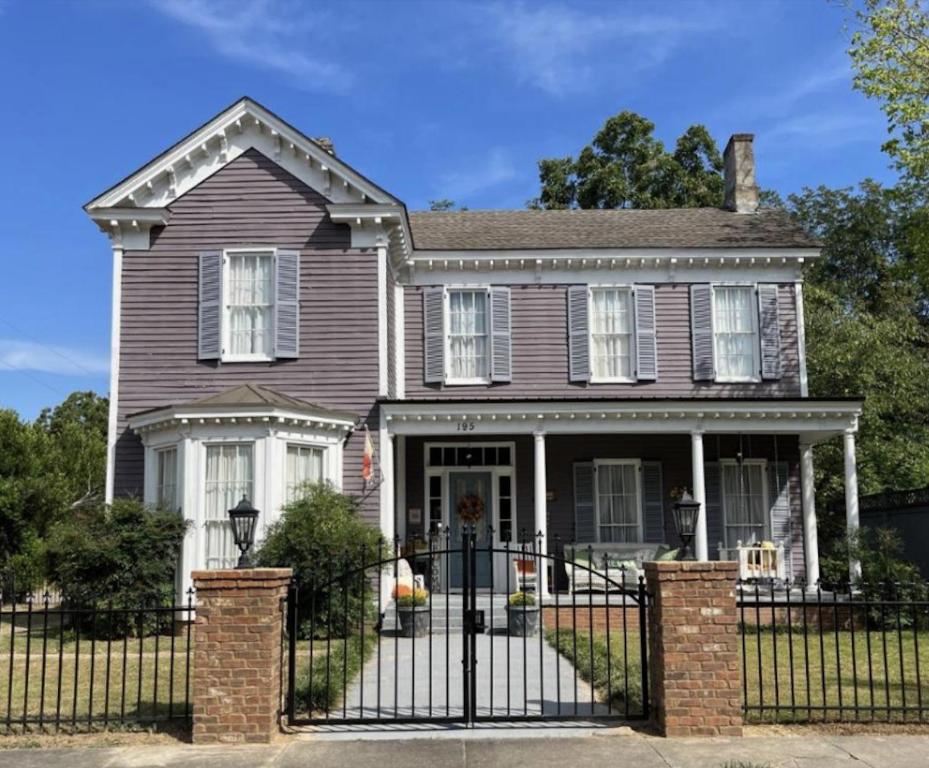 una casa con una valla de hierro forjado negro en The Wynne House Inn, en Holly Springs