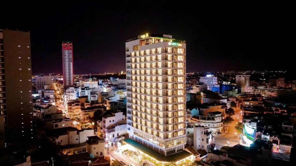 a tall building in a city at night at Areca Hotel Nha Trang in Nha Trang