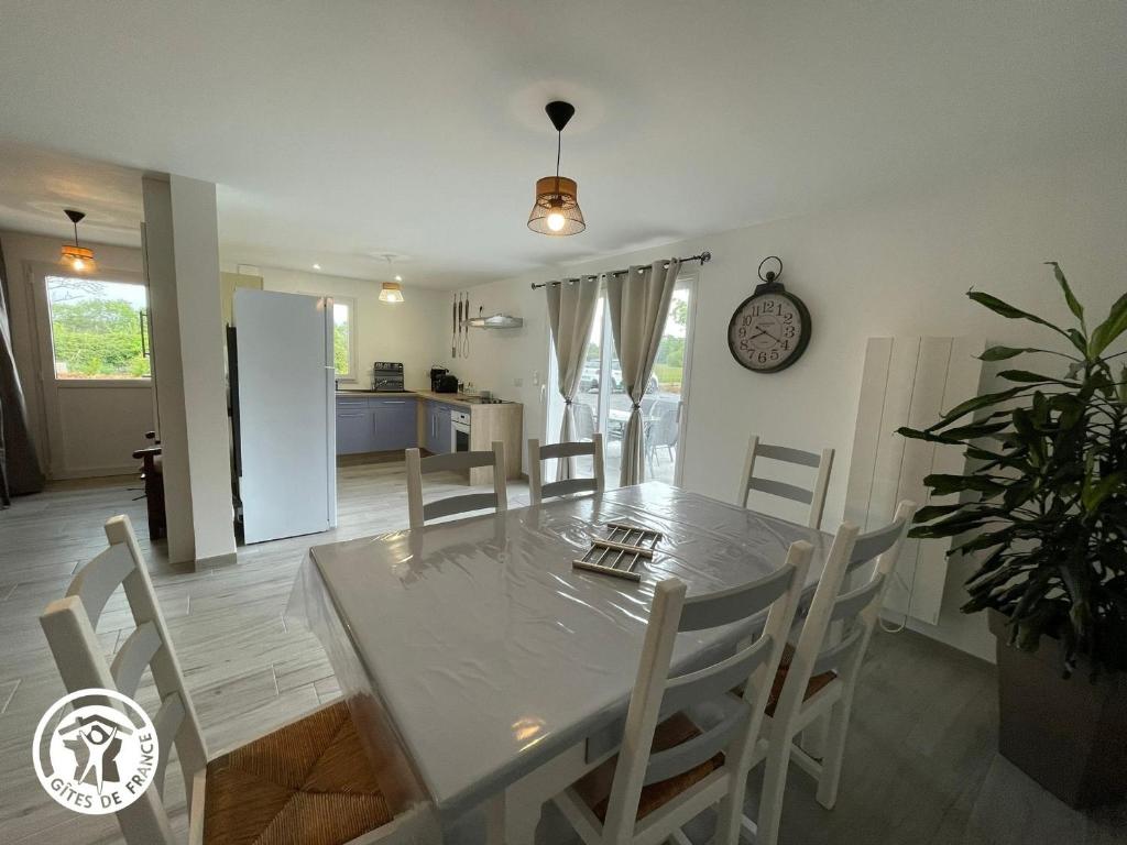 une cuisine et une salle à manger avec une table et des chaises dans l'établissement Gîte au Marais Breton: Confort, Proximité Plages, Idéal Familles et Amis - FR-1-426-548, à Saint-Gervais