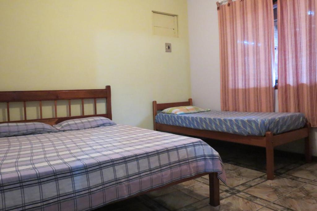 a bedroom with two beds and a window at Casa da Fran in Maresias