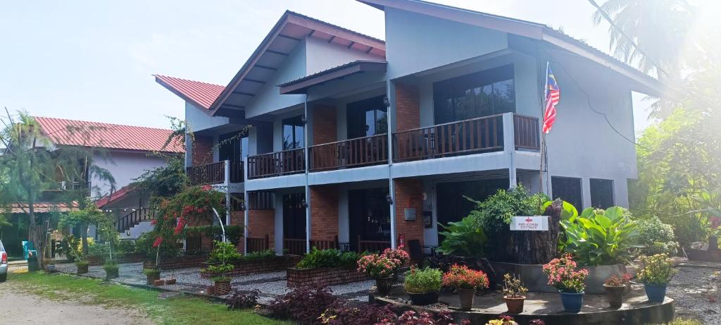 ein Gebäude mit einer Flagge davor in der Unterkunft Red Coral Cottage in Tanjung Rhu
