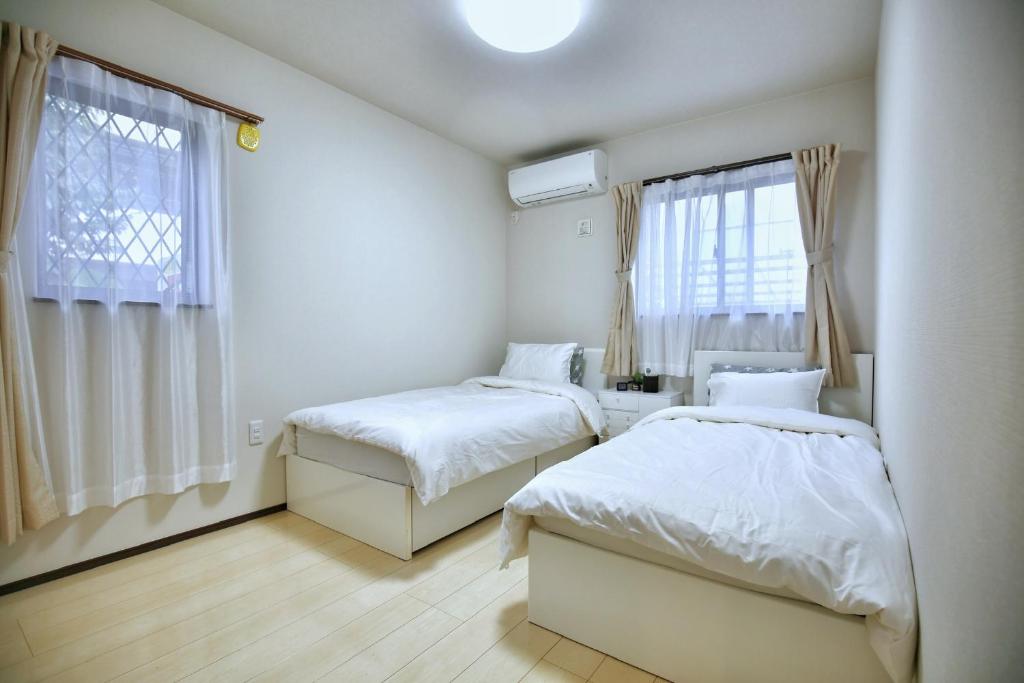 a bedroom with two beds and a window at アキラ商事 in Tokyo