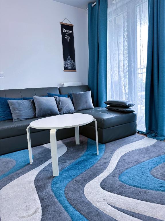 un salon avec un canapé et une table dans l'établissement Appartement à 15 mins de Paris, à Châtillon