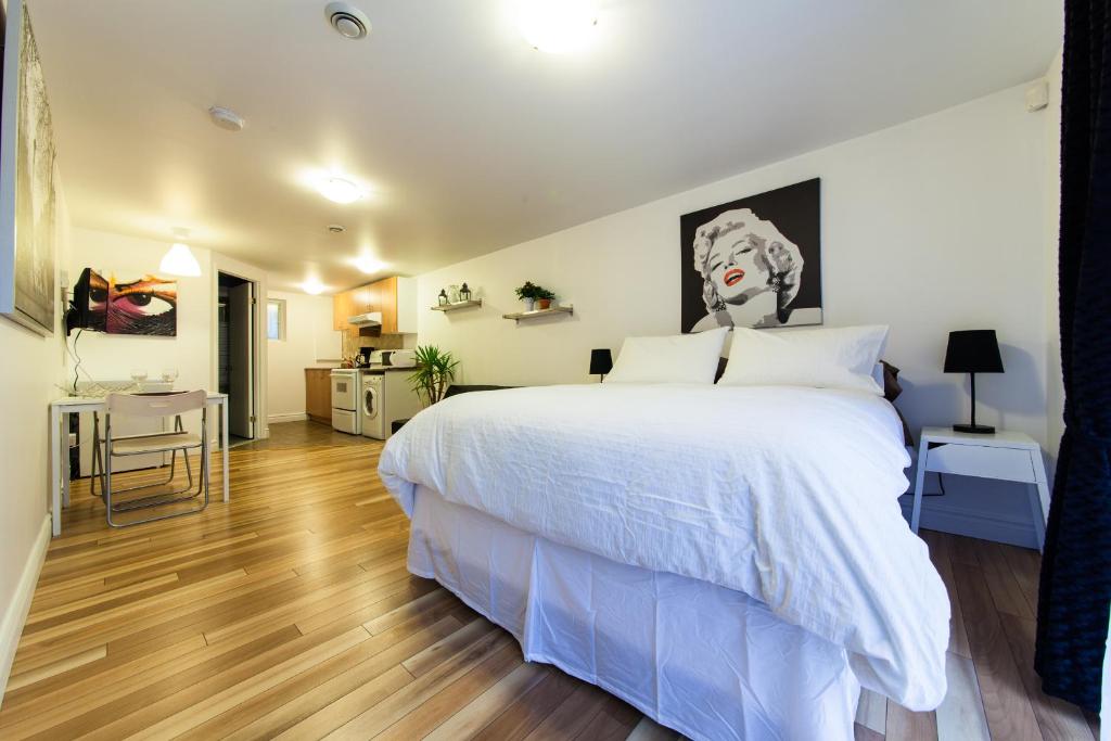 a bedroom with a large white bed and wooden floors at Le 2662 Charlemagne in Montreal