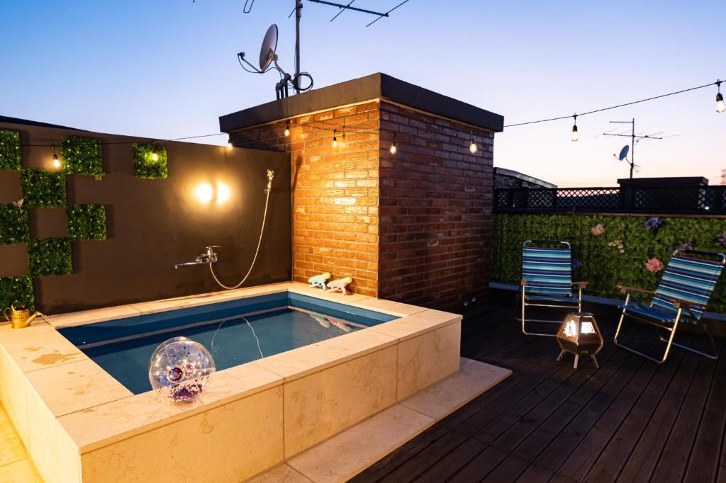 a hot tub in the middle of a patio with two chairs at The Urban Sanctuary Paju in Paju