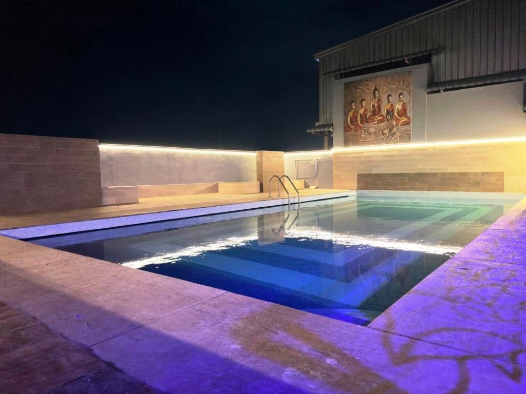ein Pool in der Nacht mit violetten Lichtern in der Unterkunft Heritage Residency By Lemongrove Hospitality in Madurai
