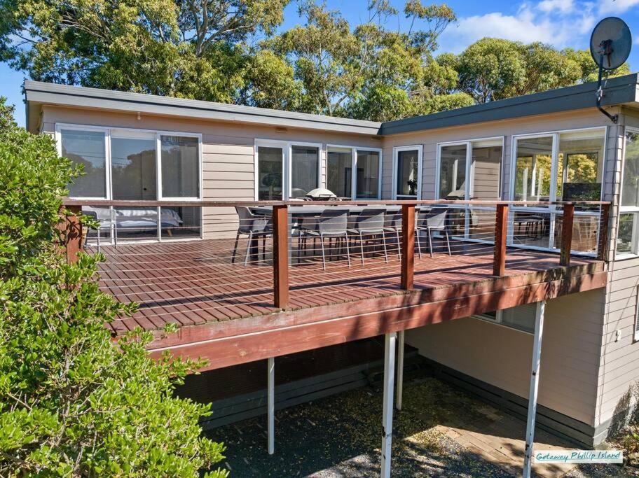 a house with a deck with a table and chairs at Cowes On Hill in Cowes