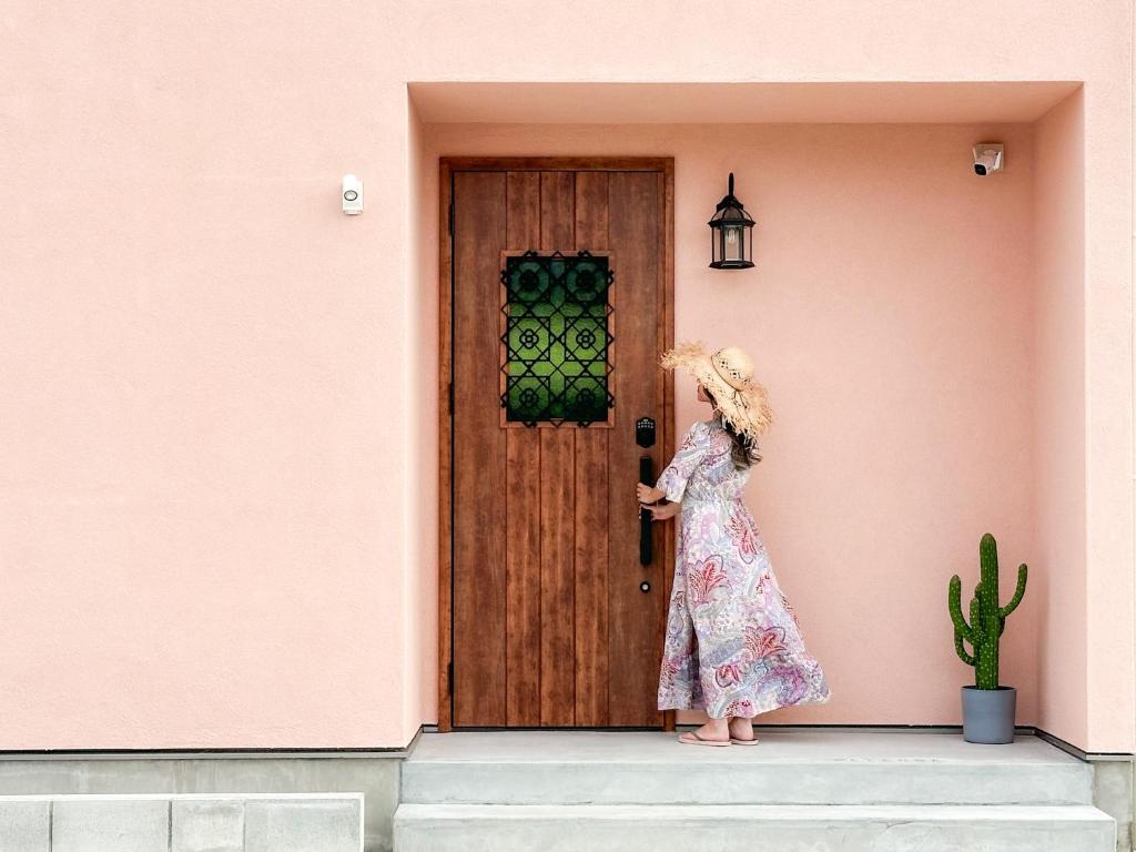 a girl in a dress standing in front of a door at Saboten in Sesoko